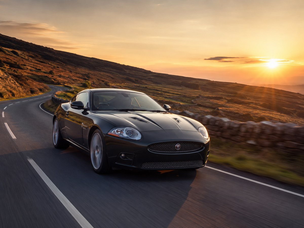 Jaguar grand tourer on a British country road at sunset